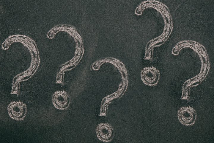 Question marks chalk drawing on blackboard background