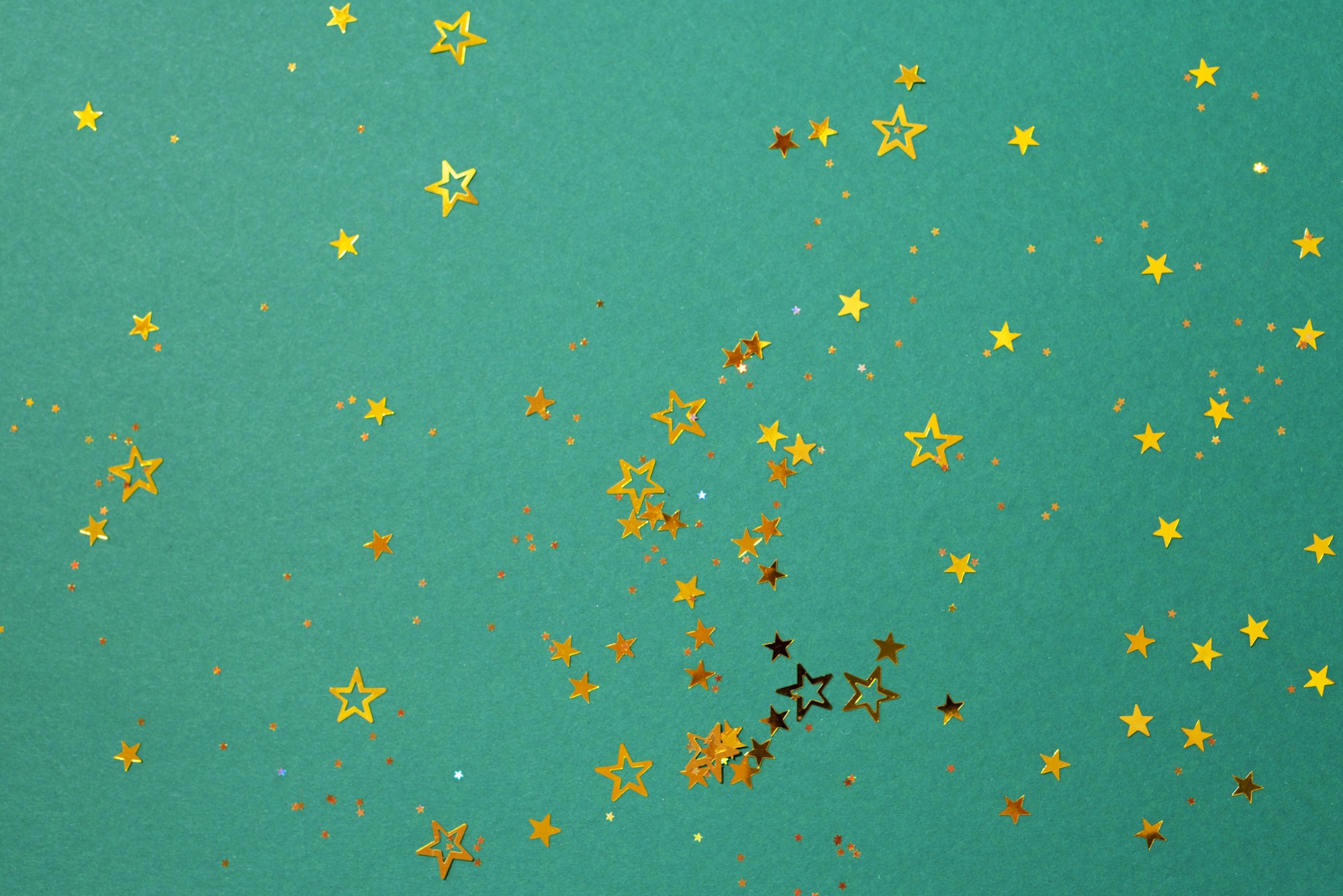Golden star sparkles on green background
